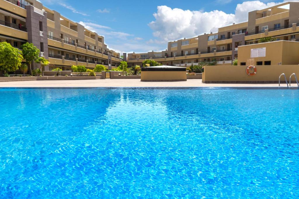 duży basen przed niektórymi budynkami apartamentowymi w obiekcie La Perla Beach Apt with Pool w mieście El Médano