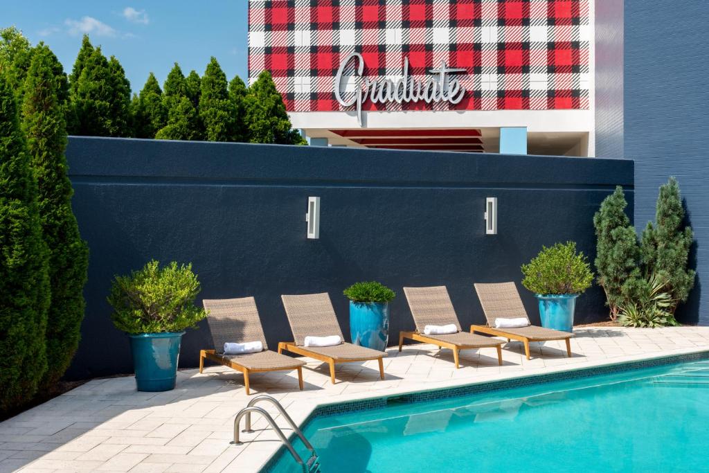 a row of lounge chairs next to a swimming pool at Graduate Fayetteville in Fayetteville