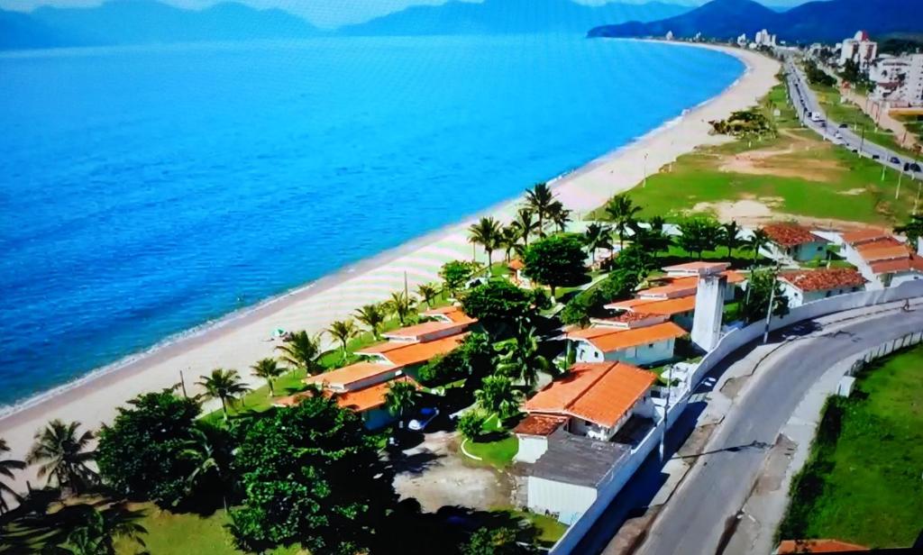 una vista aerea di una spiaggia con case e l'oceano di Ap frente para o mar a Caraguatatuba