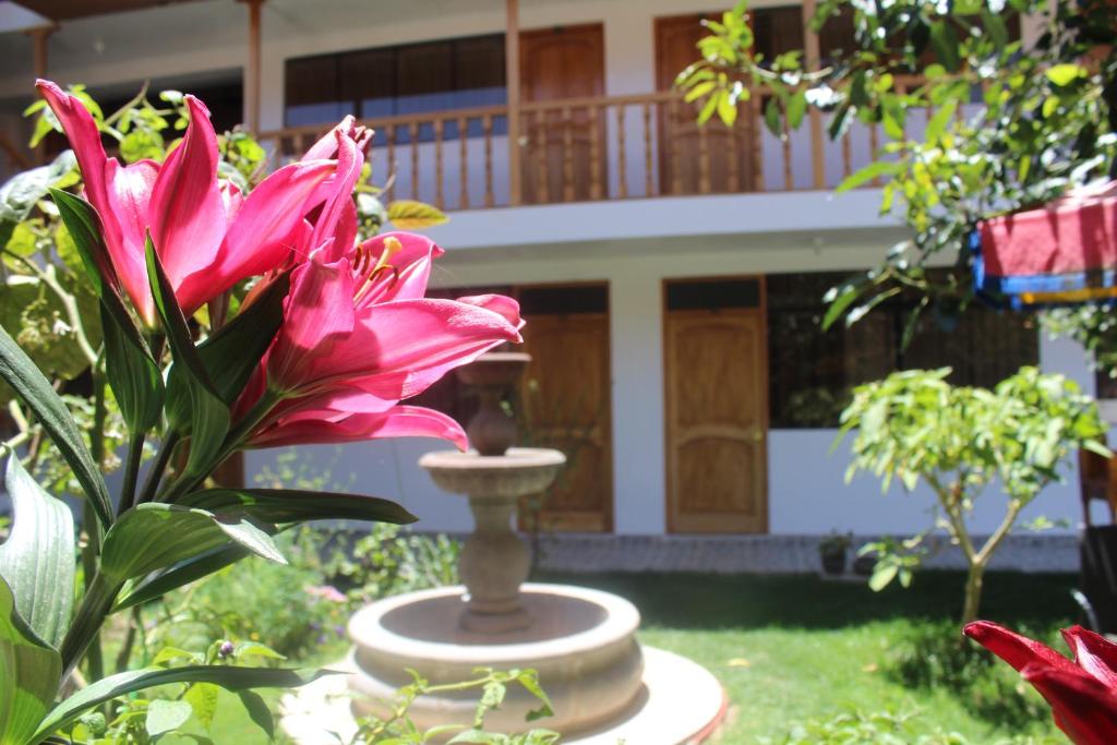una flor rosa frente a una casa en Kentis Home Ollantaytambo, en Ollantaytambo