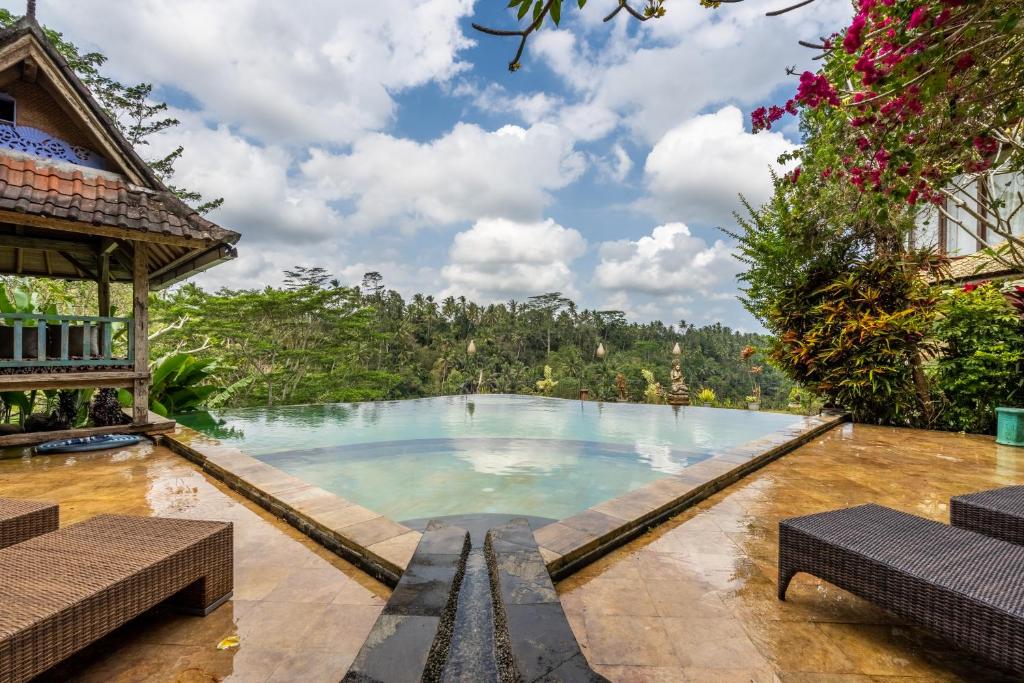 a swimming pool in the middle of a resort at Tirta Asri Ubud Villa in Ubud