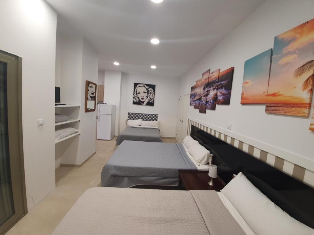 Habitación con 3 camas y cocina. en LOFT STAR THE PALMER HOUSE en Madrid