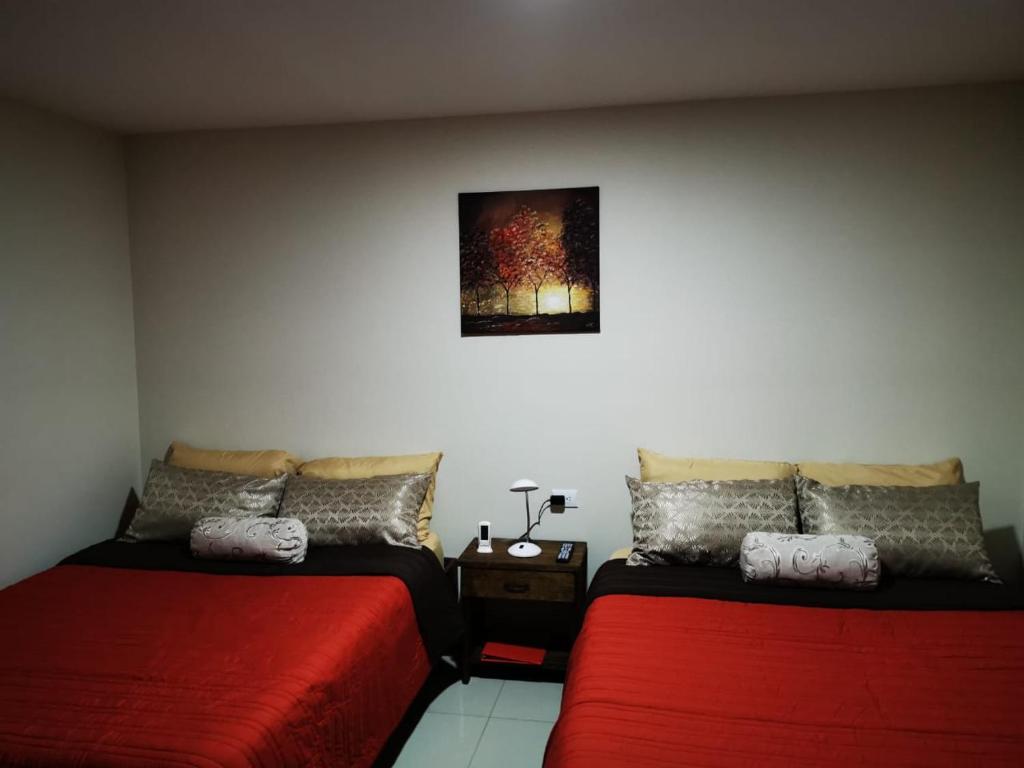 um quarto com duas camas e um quadro na parede em CASA GERANIOS # 2 em Monteverde