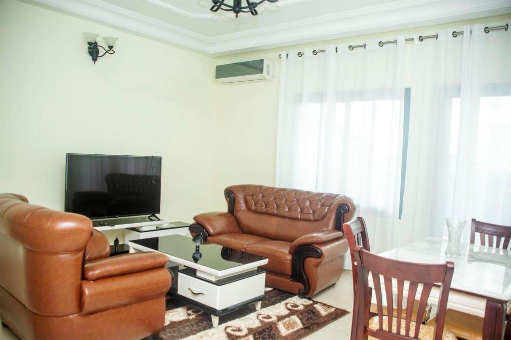 a living room with a couch and a chair and a table at T-RESIDENCE in Douala