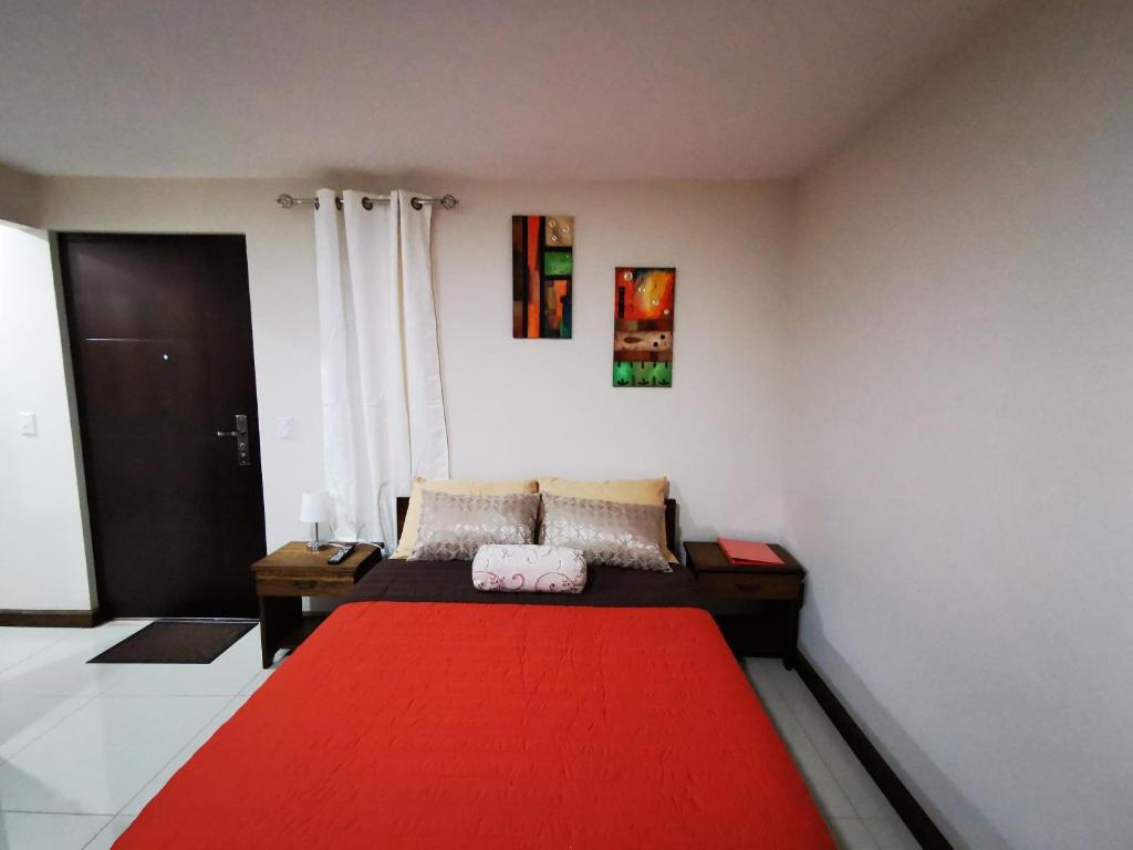 a room with a bed with a red blanket at CASA GERANIOS STUDIO #3 in Monteverde Costa Rica