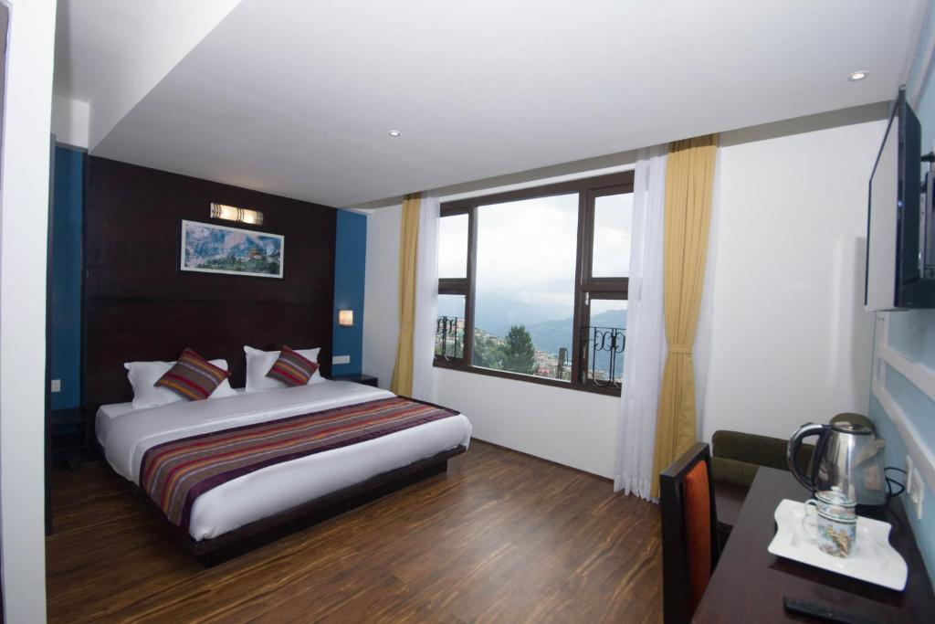 una camera d'albergo con un letto e una grande finestra di Bumblebee Bed & Breakfast a Gangtok