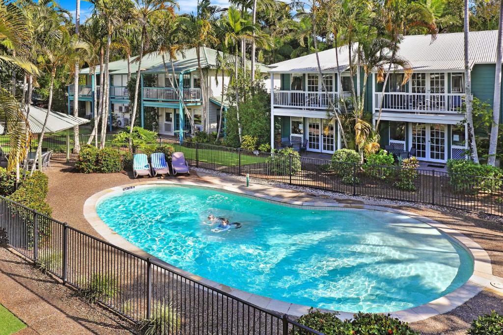 Coral Beach Noosa Resort في نوسافيل: اطلالة علوية على مسبح امام منزل