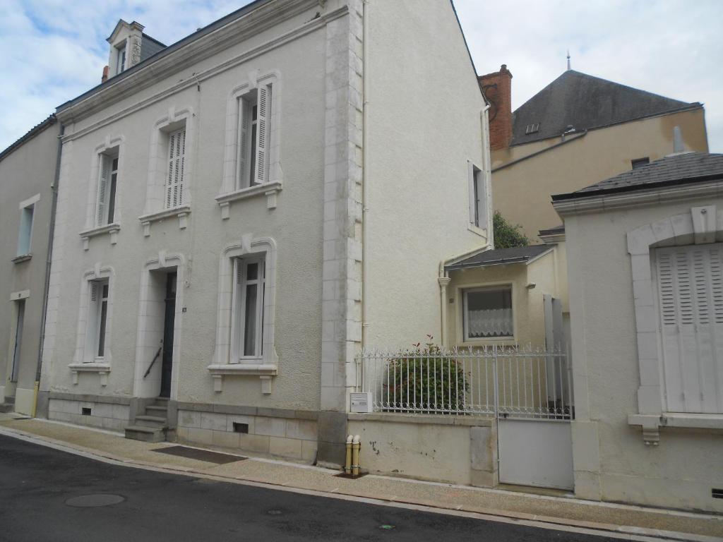 un bâtiment blanc sur le côté d'une rue dans l'établissement MAISON EN VILLE, à Airvault