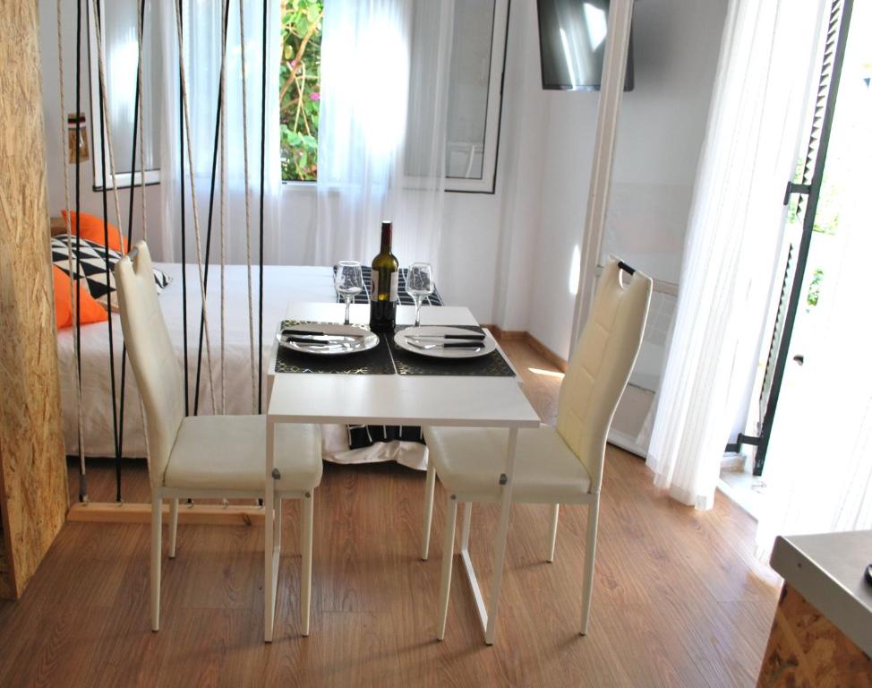 a dining room with a white table and chairs at Lilliput Studio Corfu Old Town in Corfu Town
