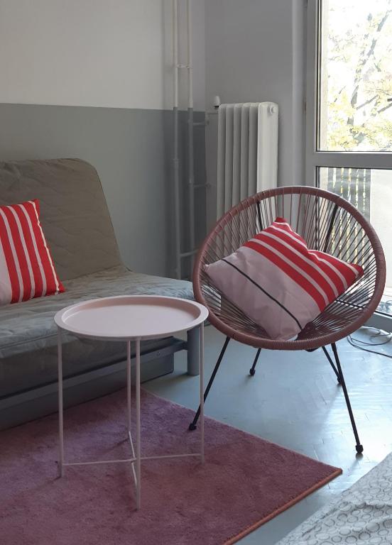 a living room with a chair and a table and a couch at Lovely Madly Apartment in Krakow