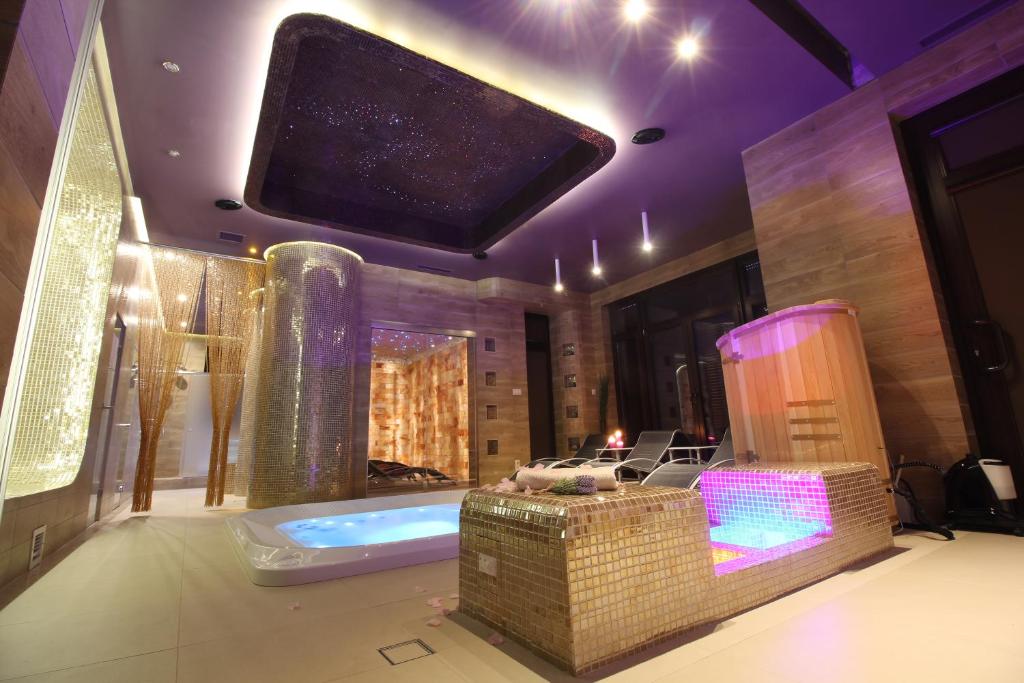 a bathroom with a tub and a tv on the ceiling at Lawendowy Zdrój Medycyna i SPA in Busko-Zdrój