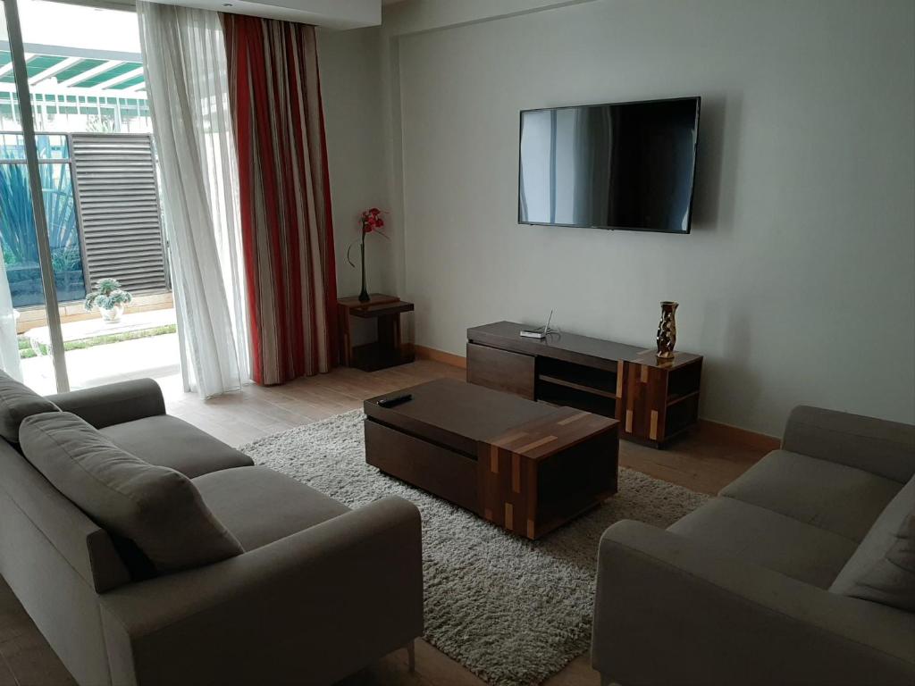 ein Wohnzimmer mit 2 Sofas und einem Flachbild-TV in der Unterkunft D2W Residency Suites in Nairobi