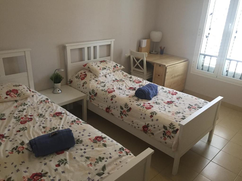 1 Schlafzimmer mit 2 Betten, einem Schreibtisch und einem Fenster in der Unterkunft Residenz TraumBlick in Puerto de la Cruz