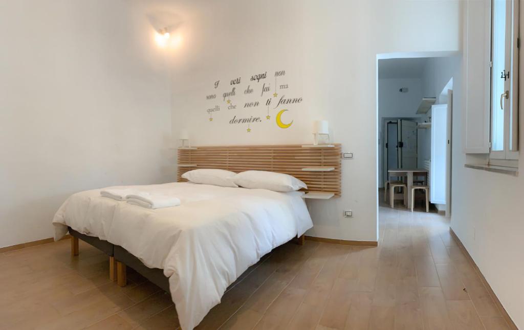 - une chambre avec un grand lit et des draps blancs dans l'établissement Santa Maria Suites, à Rome