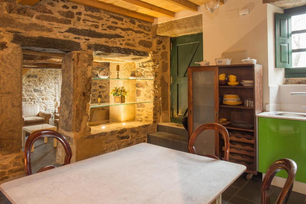 Villa Valedoso في كاباناس: مطبخ مع طاولة وكراسي في غرفة