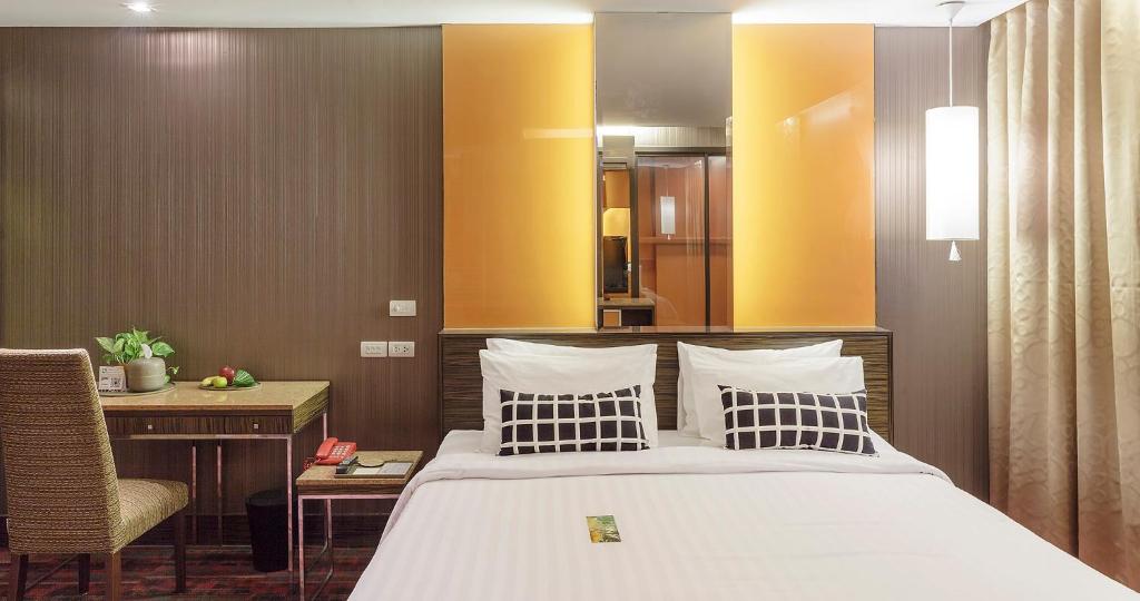 a bedroom with a bed and a desk and a chair at Tango Vibrant Living Hotel - SHA Extra Plus in Bangkok