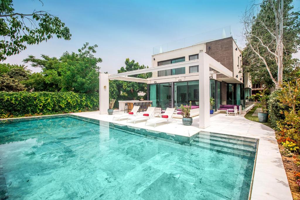 una piscina frente a una casa en The Mansion by Five Stay, en Herzliya