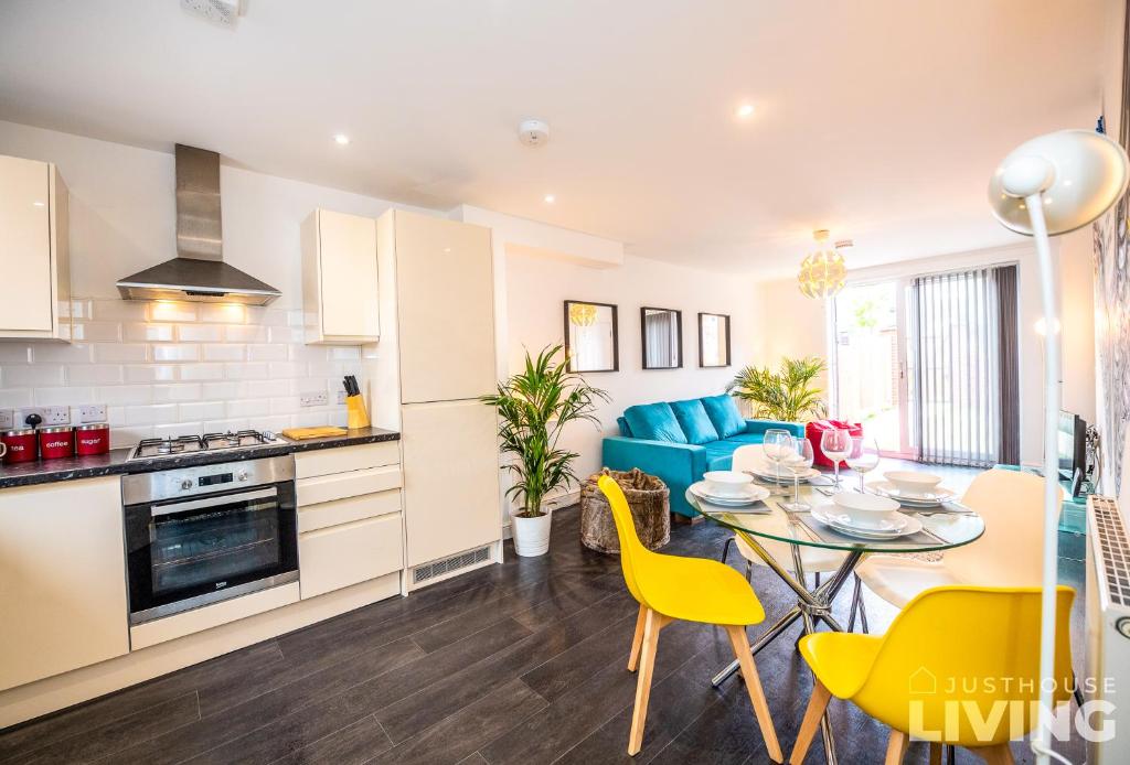 a kitchen and dining room with a table and yellow chairs at NEW Spacious Modern Townhouse FREE Private Parking in Liverpool