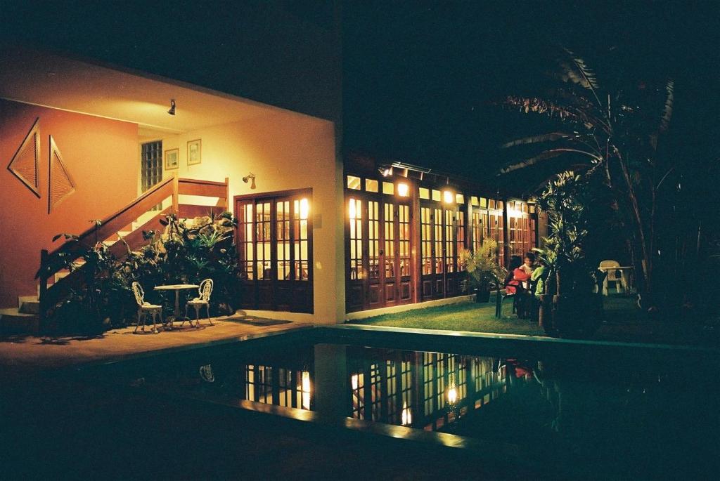 a house at night with a pool in front of it at Hotel Pousada São Rafael in Passa Quatro