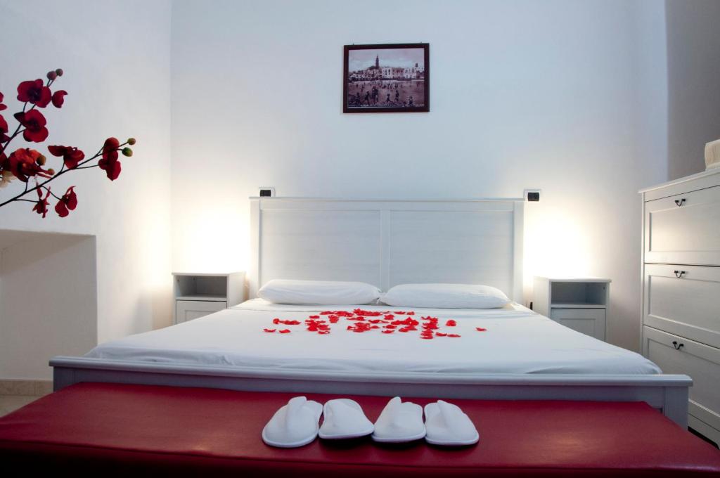 a bedroom with a bed with red flowers on it at Mamma Maria 2010 in Monopoli