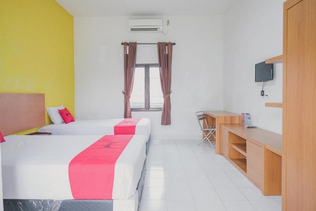 Postel nebo postele na pokoji v ubytování RedDoorz Syariah @ Pasir Putih Jambi