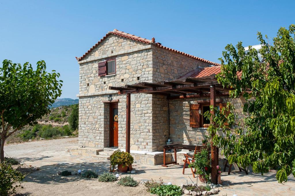 una pequeña casa de piedra con techo en Oceanis cottage house, en Órmos Koumaíïkon