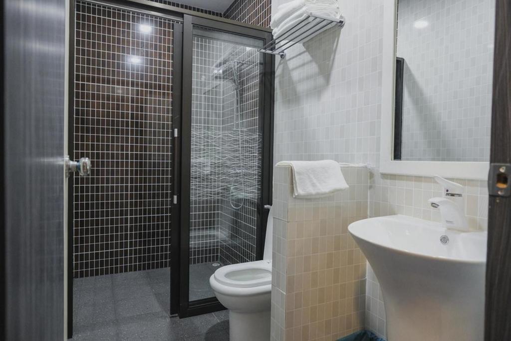 a bathroom with a shower and a toilet and a sink at RedDoorz Plus near Pantai Coastarina 2 Batam in Batam Center