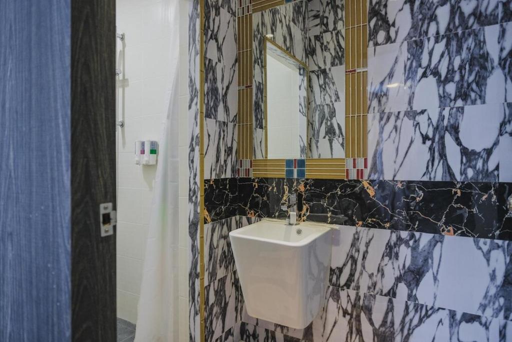 a bathroom with a sink and a mirror at RedDoorz Plus near Pantai Coastarina 2 Batam in Batam Center