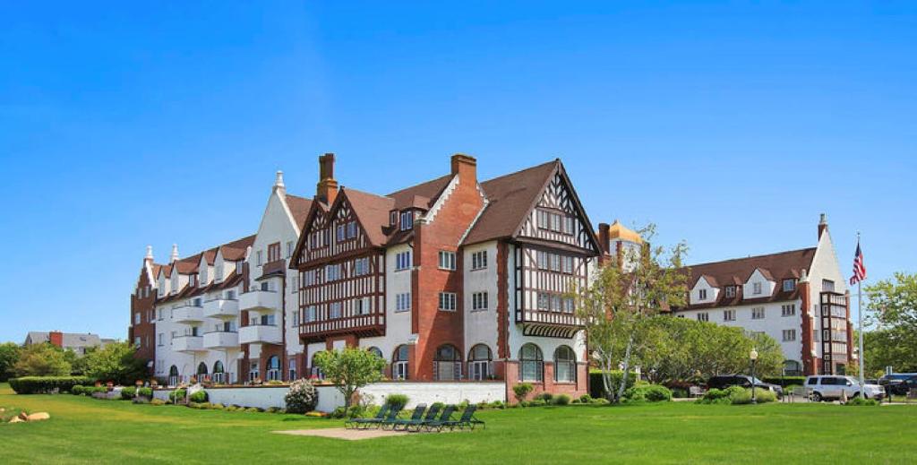 un gran edificio con un césped verde delante de él en Montauk Manor en Montauk