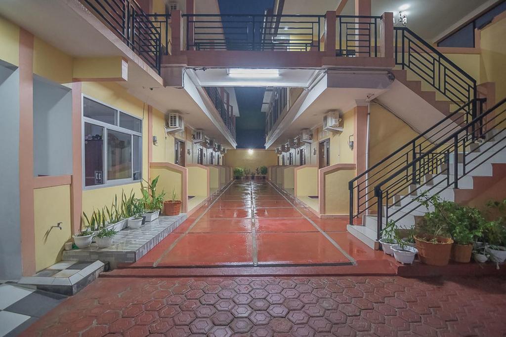 um corredor vazio de um edifício com escadas e plantas em RedDoorz near RSUD Dr. Abdul Aziz em Singkawang