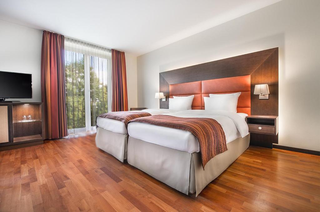 a hotel room with a large bed and a television at Aparthotel Treudelberg in Hamburg