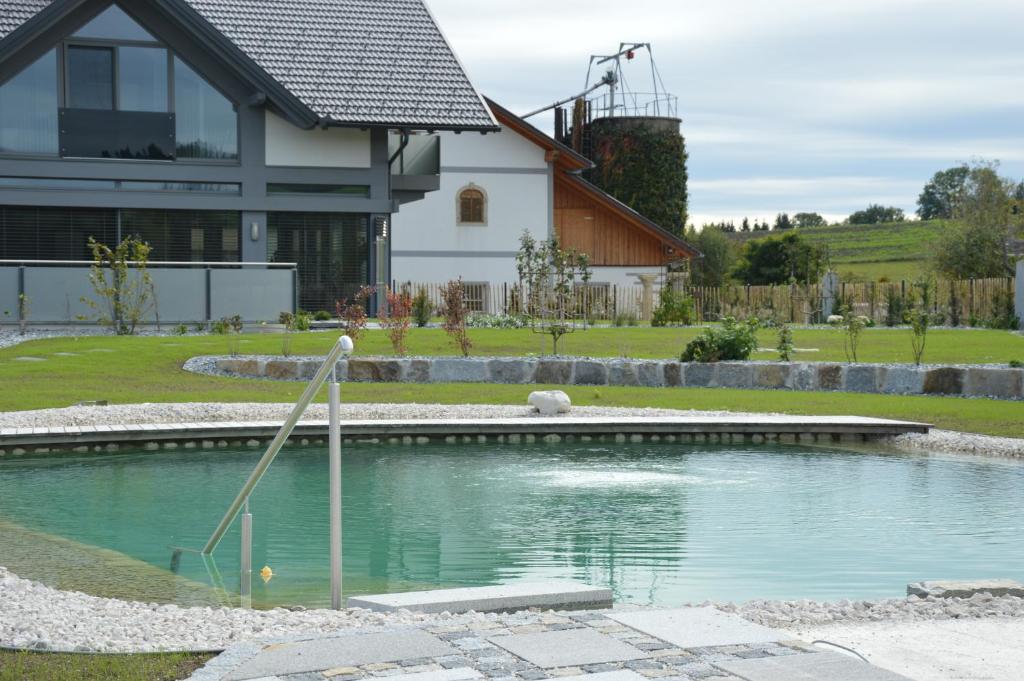 a swimming pool in front of a house at Schnatterhof in Lambrechten