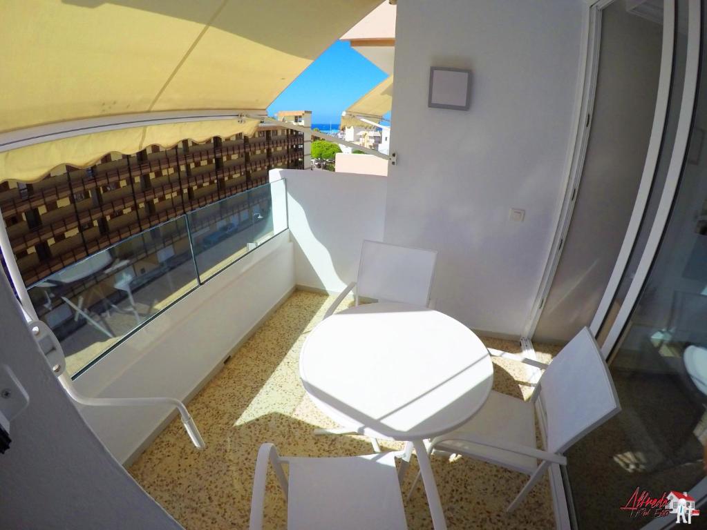 balcón con mesa blanca y sillas en Edificio Abora, en Los Cristianos