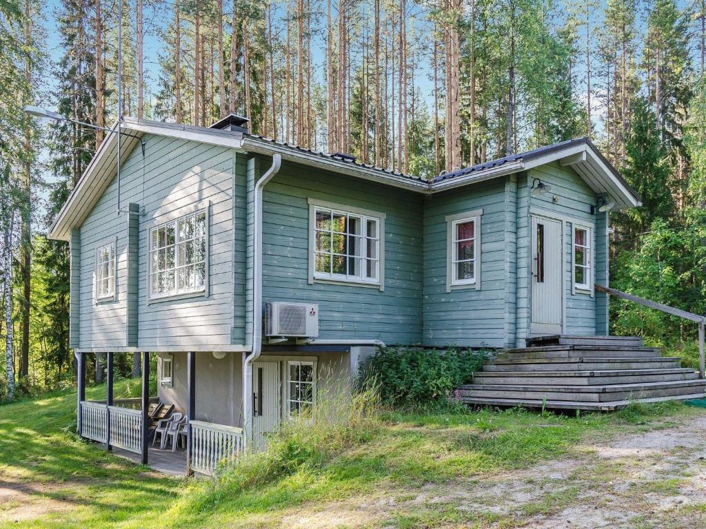 a green house in the middle of a forest at Holiday Home Tuuliranta by Interhome in Nurmes