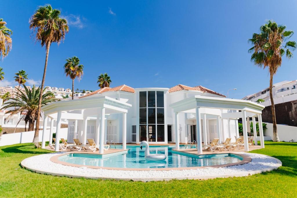 a villa with a swimming pool and palm trees at Casa Palmeras in Adeje