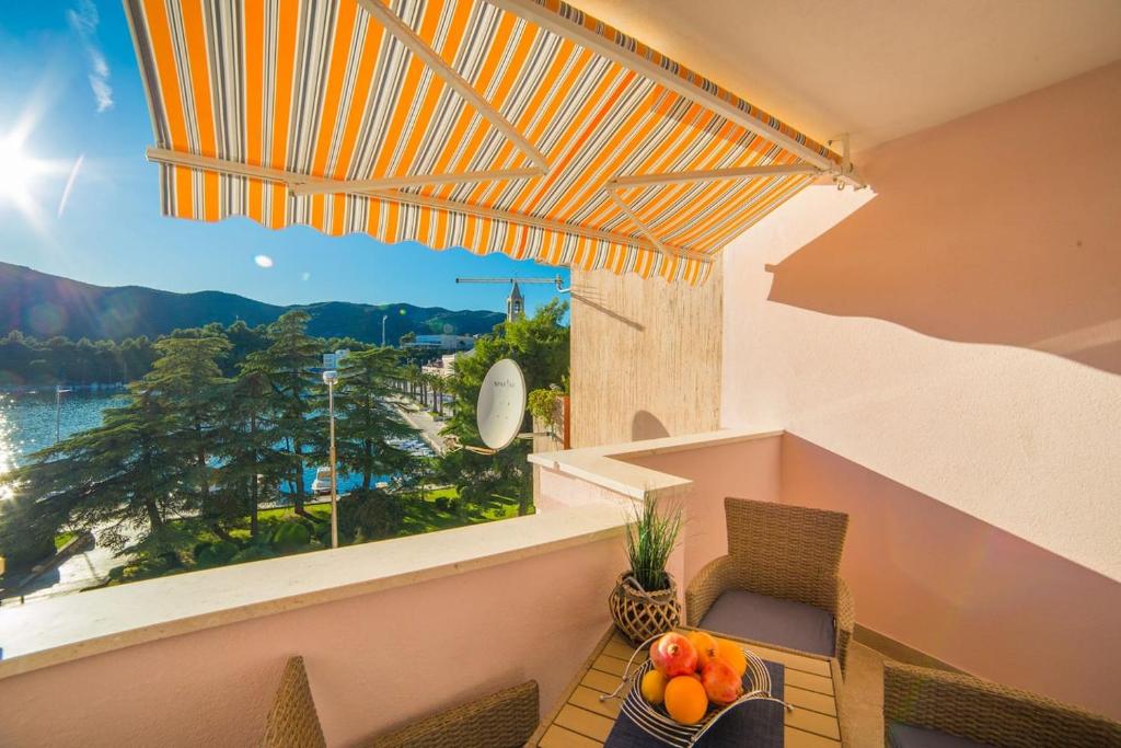 a balcony with a table with a bowl of fruit on it at Apartment Karlo - Ploče, Croatia in Ploče