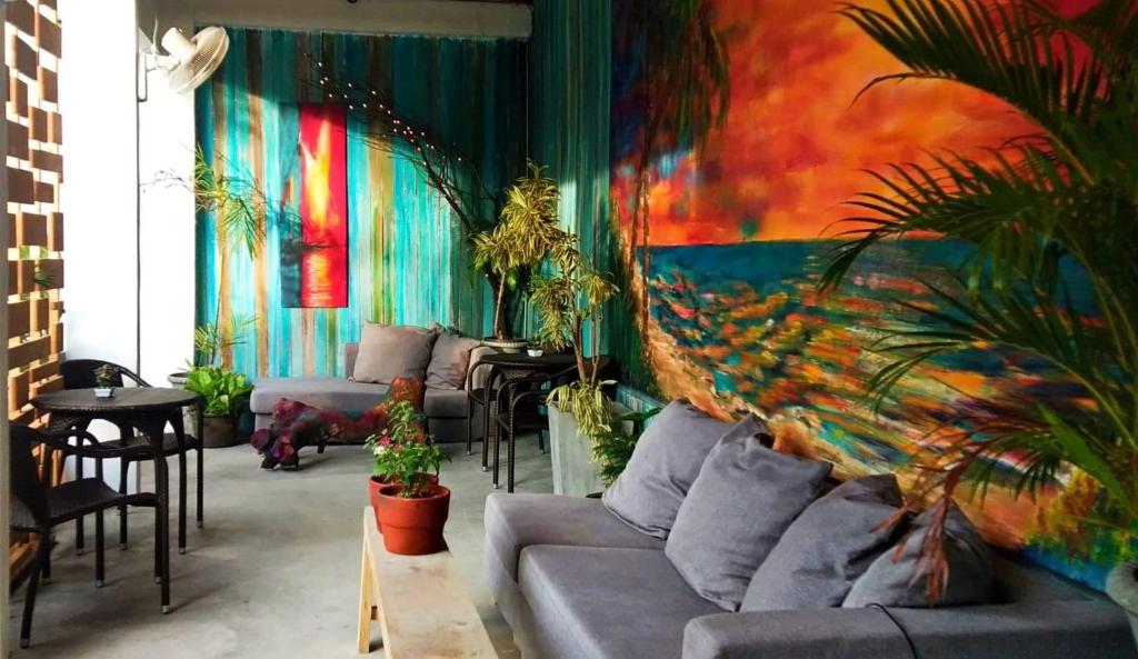 uma sala de estar com um sofá e algumas plantas em La place em Mactan
