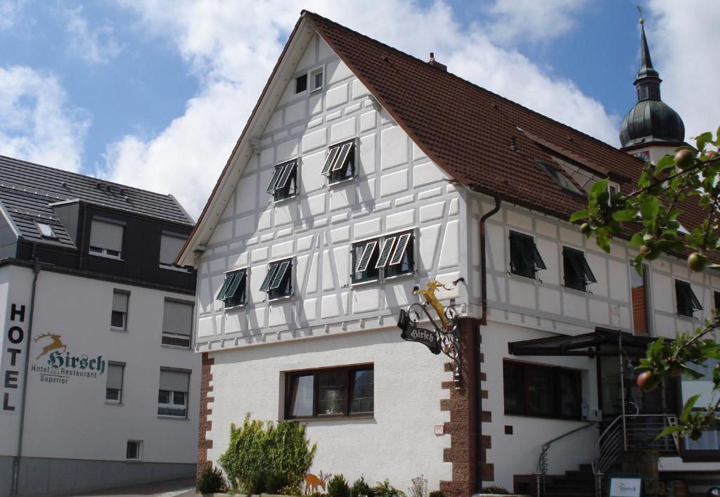 un bâtiment blanc avec des fenêtres noires sur son côté dans l'établissement Hotel - Restaurant Hirsch, à Heimsheim