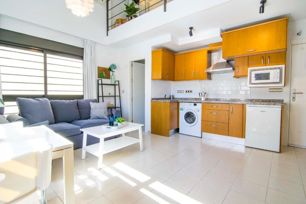 a kitchen and living room with a couch and a table at Letmalaga Economy Jábega in Málaga