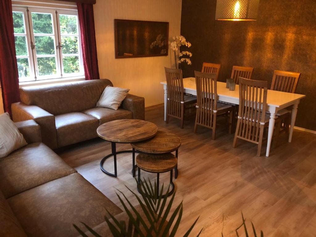 a living room with a couch and a table and chairs at Haus Onel in Schmallenberg