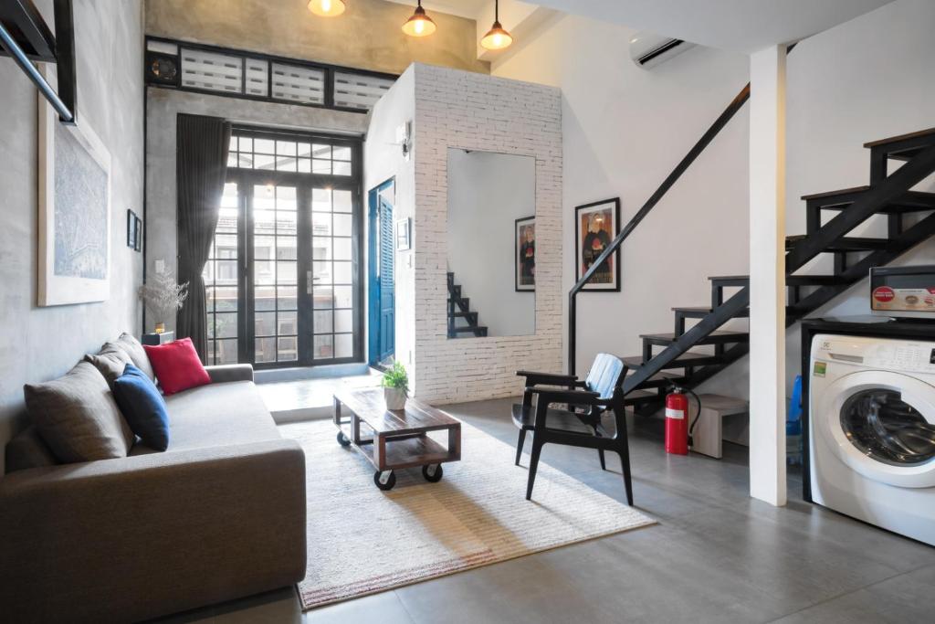 a living room with a couch and a washing machine at CIRCADIAN Industrial Loft In Heritage Building in Ho Chi Minh City