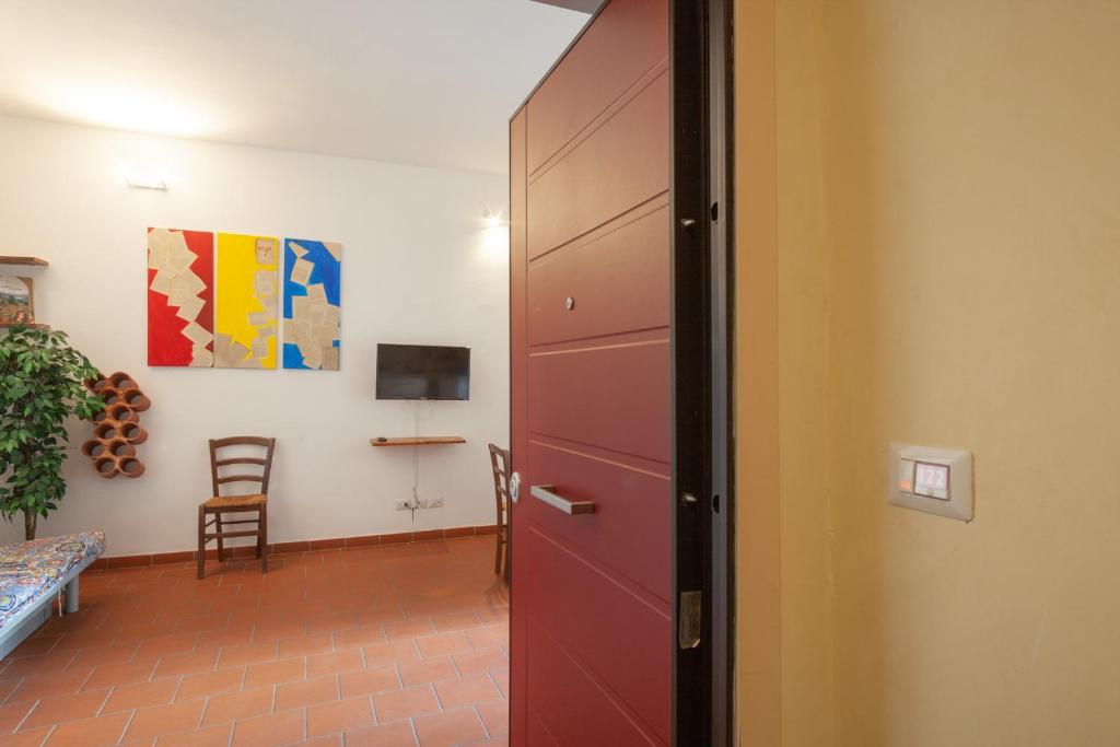 a red door in a room with a chair and a table at Appartamento 122 in Prato