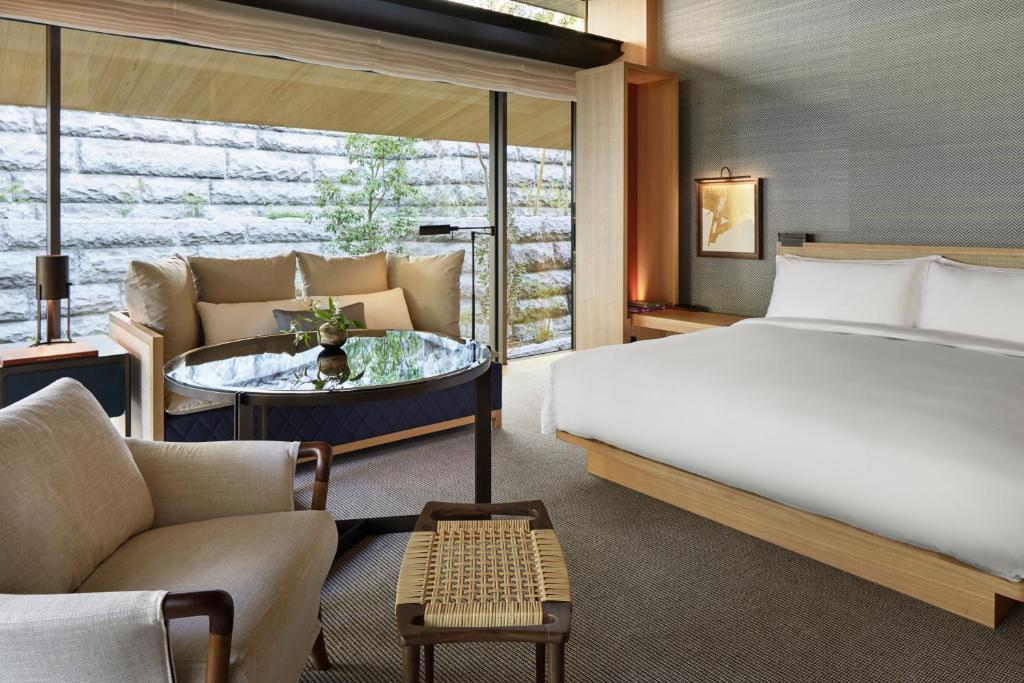 a bedroom with a bed and a couch and a table at Park Hyatt Kyoto in Kyoto