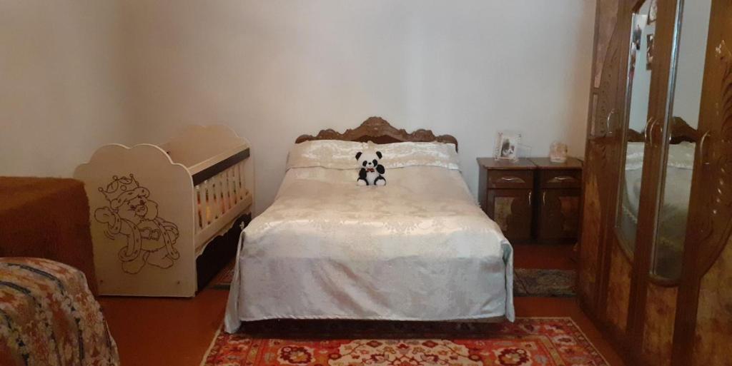 un dormitorio con una cama con dos animales de peluche en Guest House OTILIA, en Gyumri