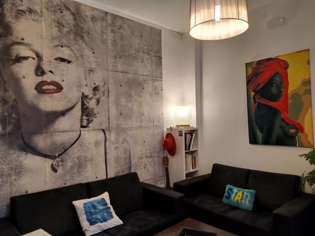 a living room with a couch and a painting on the wall at Málaga Centro Hostel in Málaga