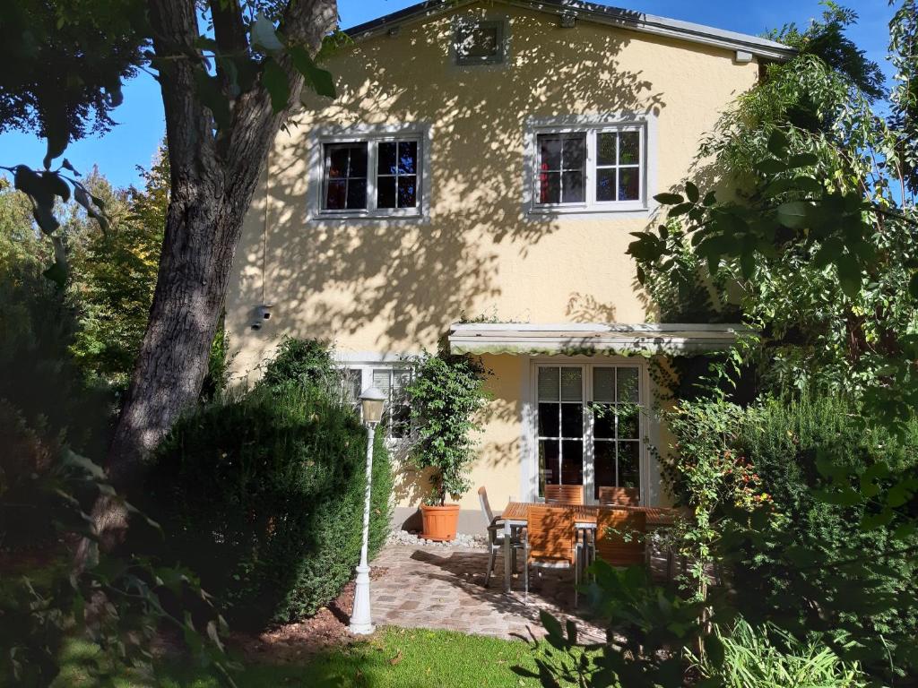 una casa con un albero di fronte di Villa Maxglan a Salisburgo