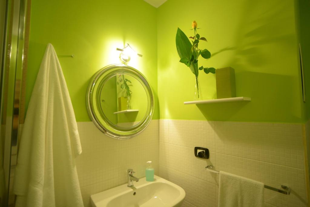 zieloną łazienkę z umywalką i lustrem. w obiekcie Casa Decò Business Stay Solution w mieście Tarent