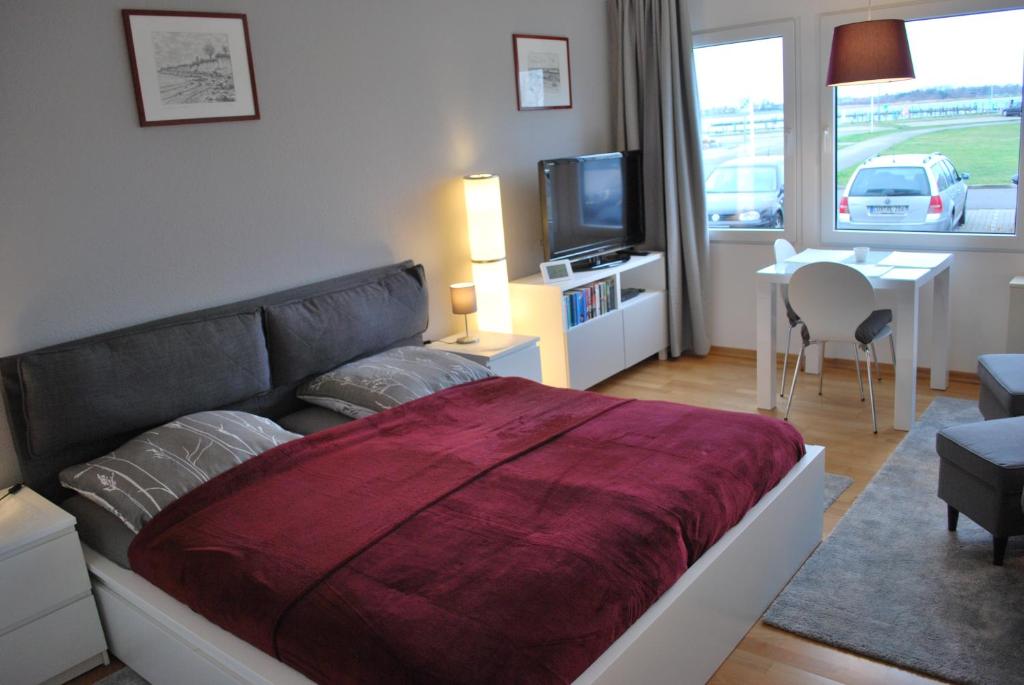 Un dormitorio con una cama con una manta roja encima. en Ferienvermietung Fehmarn Hygge Südstrand WHG 62 - 010, en Fehmarn