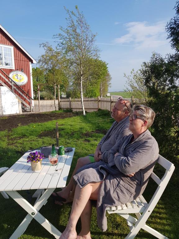 two people sitting on a bench at a picnic table at Lanthotell Lögnäs Gård in Laholm