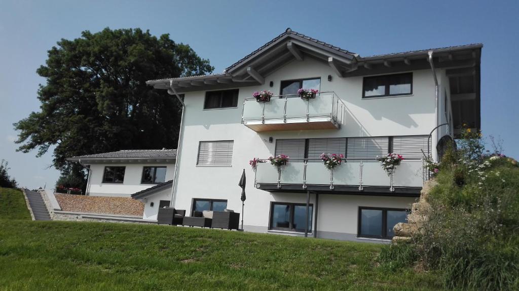 un edificio bianco con fioriere sui balconi di Ferienwohnung Alpenpanorama a Hopferau